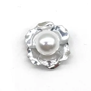 Detailed view of silver flower shoe charm with textured petals and a center white pearl