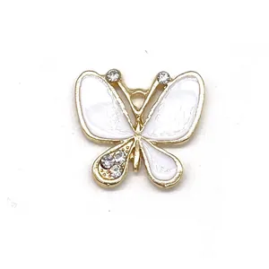 Detail of butterfly shoe charm with white enamel, gold frame and sparkling rhinestones