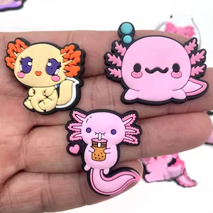 Trois breloques mignonnes en PVC axolotl pour sabots, présentées dans la main