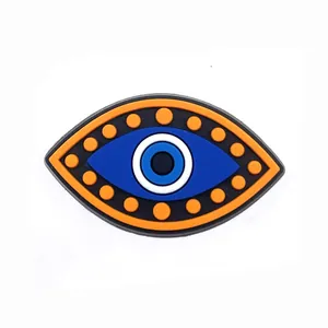 Detail van PVC Evil Eye schoenbedeltje met blauwe iris en oranje rand voor klompen
