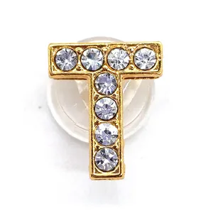 Detail of gold letter T charm featuring sparkling rhinestones for shoe decoration