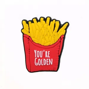 Detail of PVC shoe charm featuring French fries in a red bag with You're Golden text