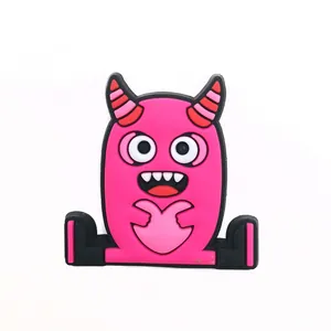 Detail of a bright magenta cartoon monster shoe charm with a heart-shaped hand gesture