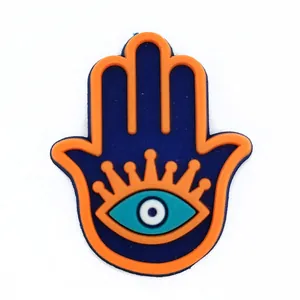 Hamsa hand bedeltje voor klompen met blauw en oranje evil eye ontwerp van PVC