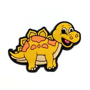 Nahaufnahme eines gelben PVC-Cartoon-Dinosaurier-Schuhanhängers für Clogs