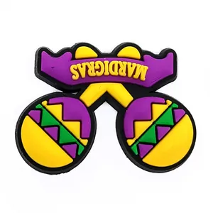 Close-up of Mardi Gras shoe charms with purple, yellow, and green maracas and banner