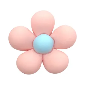 Detail of pink resin flower shoe charm with light blue core and matte finish