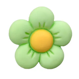 Close-up of a resin flower charm in green and yellow for garden clog decoration