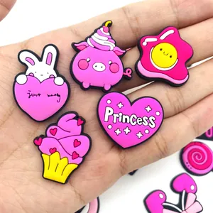 Gros plan de charms en PVC rose pour chaussures avec lapins et cœurs dans la main