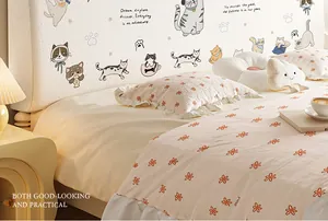 Detail of plush headboard cover featuring cute cat illustrations and soft cream fabric