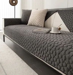 Detailed view of dark grey quilted flannel sofa cover with geometric diamond stitching