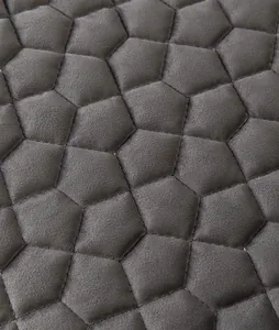 Macro detail of dark grey quilted flannel fabric with geometric pentagon stitching