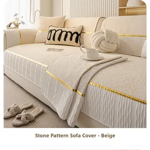 Detail of beige stone texture chenille sofa cover with gold trim and pleated skirt