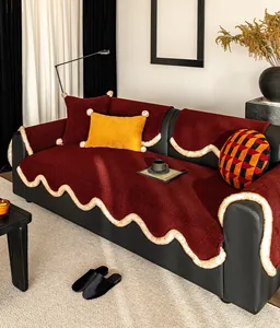 Detail of plush wine red sofa cover with white wavy faux fur trim and colorful cushions