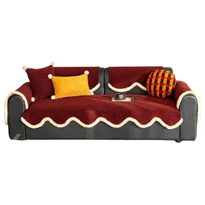 Burgundy plush sofa cover set with scalloped edges and white pompoms on black couch