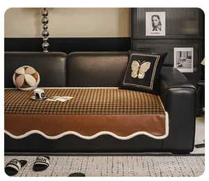 Detail of houndstooth sofa cushion with leather patchwork and wavy plush edging