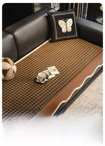 Detail of houndstooth sofa cushion featuring brown leather edges and wavy white trim