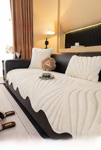 Detail of plush cream velvet sofa cushion with wavy quilting on dark leather sofa