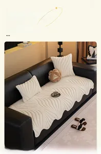 Detail of plush cream sofa cover with wavy quilted texture and scalloped edges on leather