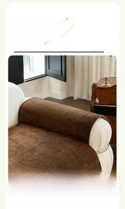 Texture détaillée du protège-accoudoir en velours côtelé marron sur canapé