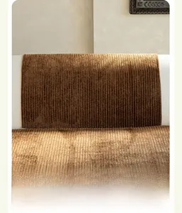 Détail d'une housse de coussin de canapé en velours côtelé marron à rayures verticales