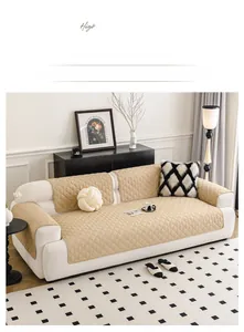 Close-up of beige quilted cotton sofa cover with diamond pattern and non-slip texture
