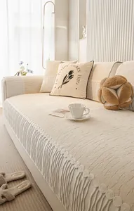 Detail of cream chenille sofa cushion with elegant wave tassel fringe and soft texture