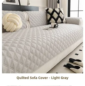 Detail of light grey sofa cover featuring quilted diamond patterns and fabric texture