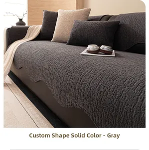 Detail of grey chenille sofa cover with scalloped edges and textured fabric surface
