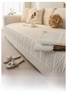 Detail of beige chenille sofa cover with embossed wave texture and floral lace trim
