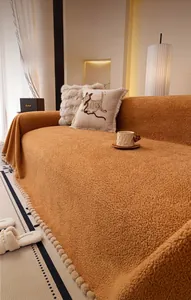 Détail de la housse de canapé en laine d'agneau caramel avec pompons décoratifs chic