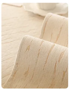 Macro shot of beige chenille sofa cushion showing fine edge piping and woven texture