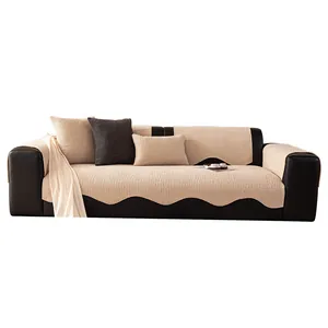 Minimalist beige chenille sofa cover with scalloped edges on a brown leather couch