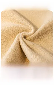 Macro detail of thick beige teddy velvet fabric showing soft curly plush texture