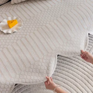 Beige quilted chenille sofa cover with geometric patterns and elegant wavy scalloped edges