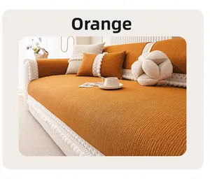 Detail of orange sofa cover with vertical striped texture and white crochet tassel trim