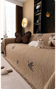 Detail of latte-colored rabbitwool sofa cover with butterfly pattern and tassel fringe