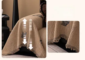 Macro detail of camel sofa throw blanket with black butterfly patterns and fringe edge