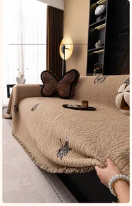 Close-up of thick rabbit plush sofa cover with butterfly pattern and tassel fringe detail