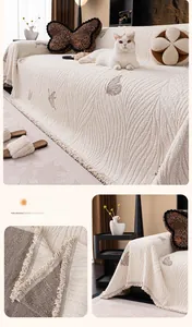 Detail of cream white thickened fabric sofa cover with butterfly patterns and tassels