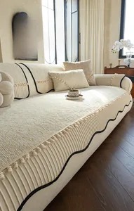 Detail of cream chenille sofa cover showing striped texture and elegant fringe trim