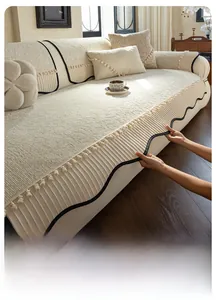 Detail view of cream chenille sofa cover with ruffled skirt and elegant tassel accents