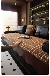 Detail of chenille sofa cushion featuring brown checkered pattern and wavy leather edge