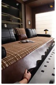 Detailed view of brown checkered chenille sofa cover with leather trim and wavy lace edge