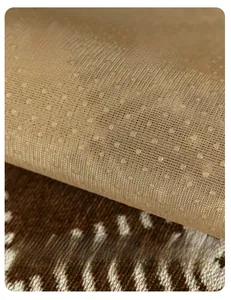 Detail of anti-slip granules on chenille sofa cover with thick beige textured fabric