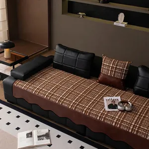 Brown plaid chenille sofa cover with leather wavy edges and matching pillows on leather sofa