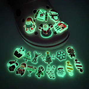 Macro detail of glow-in-the-dark Christmas shoe charms for clogs in dark environment
