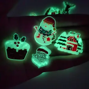 Glow in the dark Christmas charms showing luminous snowman and Santa icons in hand