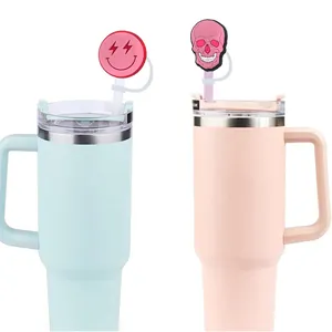 Pink and mint green 40oz insulated tumblers with smiley face and skull straw cover caps
