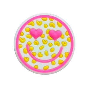 Macro shot of a cute round PVC shoe charm with pink heart eyes and a smiley face